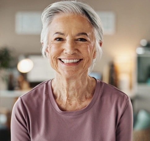 Smiling senior woman showing natural-looking dental implants in Carthage