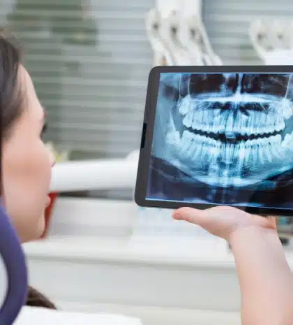 Patient viewing digital panoramic dental X-ray on screen for diagnosis in Carthage clinic